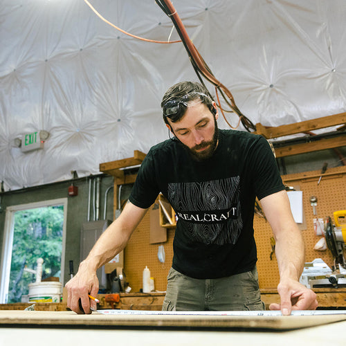 Craftsman measuring a door panel 