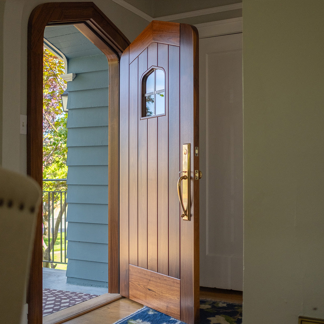 Photo of custom Black Walnut Gothic arch top door with flush panels and custom leaded glass window