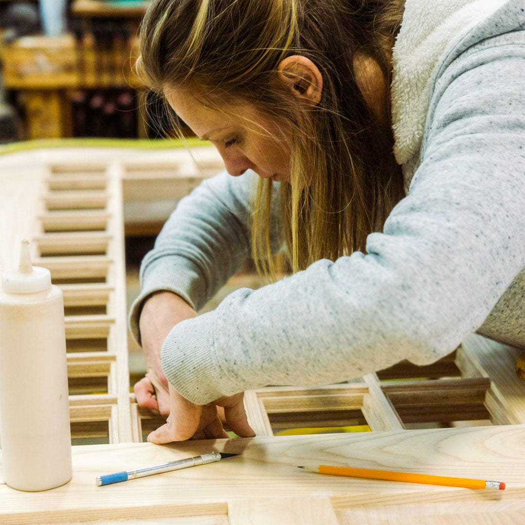 Craftswoman adding glass to a door